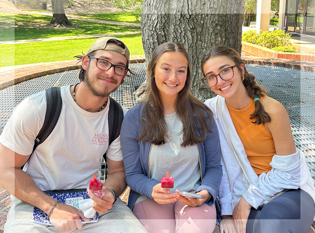 Three students enjoying popsicles on campus